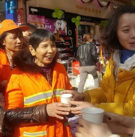 工作人員親切地給環(huán)衛(wèi)工人們遞上溫水。